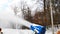 Snow cannon making artificial snowy powder near piste, mountain track. winter resort on bright sunny day. downhill slopes, sport a
