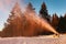 Snow cannon in winter mountains. Snow-gun spraying artificial ice crystals. Machine making snow