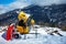 Snow canon at ski resort with mountains on background