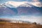 Snow caped mountains. Morning fog in valley. Misty hills