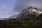 Snow capped mountain peak lit by rising sun