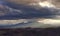 Snow capped mountains of the apennine and valleys at sunset between clouds and sun rays