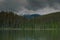 Snow capped mountains with dark and light clouds.