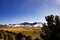 Snow-capped mountains and yellowed grass.