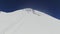 Snow-capped peak of Mount Elbrus with gentle slopes with ski runs and tourists