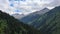 Snow-capped peaks of the mountains of the Zailiysky Alatau, visible in the distance among the slopes of the mountains.