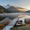 Snow-capped tranquility: Morning lake scene with autumn trees.