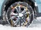 Snow chains fitted on a car wheel