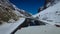 Snow-Clad Mountains Bordering a Snowy, Narrow Road in Shinkula Pass