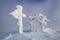 Snow coted building and cross on a snow covered lawn. Fog on the background. Fantastic winter landscape