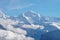 Snow covered Alpine range rises above the clouds