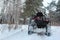 Snow covered ATV in winter forest