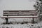 A snow covered Bench in a Park