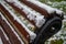 Snow covered bench for relaxing in the park on the observation deck. Autumn, the first snow. Close-up