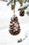 Snow covered branches of the Christmas tree decorated with toys. New Year`s decorations made of pine cones