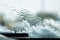 Snow-covered car windshield with melted snow drops and windshield wipers. Copy space