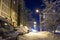 Snow-covered city courtyard in the late evening. Magical landscape. Snow-covered cars parked along high-rise buildings