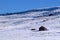 Snow covered Colorado hillside with log cabin