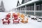 snow-covered deck chairs near a winter lodge