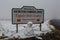 Snow covered fells at the Northumberland / Cumbria border sign with a frightening looking snowman in the foreground