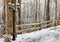 Snow covered fence and light post in winter