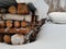 Snow covered firewood stacks outside in the cold arctic circle wintertime