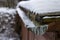 A snow-covered gutter on the roof. Snow lying on the roof and gutter for drainage