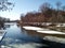 Snow-covered ice floes of a beautiful rounded shape float along a spring river with forested banks on a sunny March day.