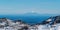 Snow covered Mount Taranaki, or Egmont, an active volcano, viewed from far away in tongariro national park, New Zealand.