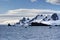 Snow covered mountain in Antarctica with inflatable boats in front