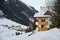 Snow-covered mountain chalet with wooden balconies at the foot of the mountain in winter after