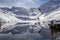 The snow-covered mountain and its reflection in Lac du Lou near Val Thorens resort