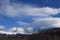 Snow-covered mountain in the Pyrenees covered with lenticular clouds, France