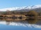 Snow covered mountain range reflected in lake at Butcher\'s Dam, Central Otago, New Zealand