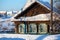 The snow-covered old log house with wooden shutters. Village Visim, Russia.