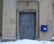 Snow-covered, padlocked, scarred door of the post office entrance