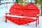 Snow-covered park bench in the shape of a heart