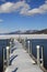 Snow covered pier on melting waters of lake