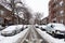 Snow Covered Residential Street in Astoria Queens New York during Winter with Homes and Parked Cars