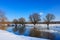 Snow-covered river bank on a sunny winter evening. Winter landscape