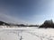 Snow covered river under blue sky