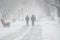 A snow-covered road with people in a storm,blizzard or snowfall in winter in bad weather in the city.Extreme winter weather