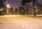 Snow covered roads in the night park with lanterns in the winter. Benches in the park during the winter season at night.