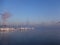 Snow covered rocks by the Baltic Sea on extremely cold winter morning with thick sea smoke on the background