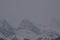Snow Covered Rocky Mountains with Hazy Grey Sky