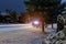 Snow covered rural road car light trails in residential area