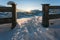 Snow covered rural winter landscape seen through fence during sunset, Wildermieming, Tirol, Austria