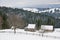 Snow covered rustic cabins in the woods in winter.