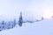 Snow-covered ski slope in the mountains with a lift and skiers skating away