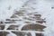 Snow covered small paving tiles, the slabs after a snowfall. Winter pavement background. Use for art work, for example.